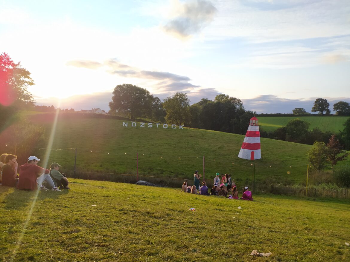 The sun setting on a grassy hill at Nozstock: The Hidden Valley Festival 2023