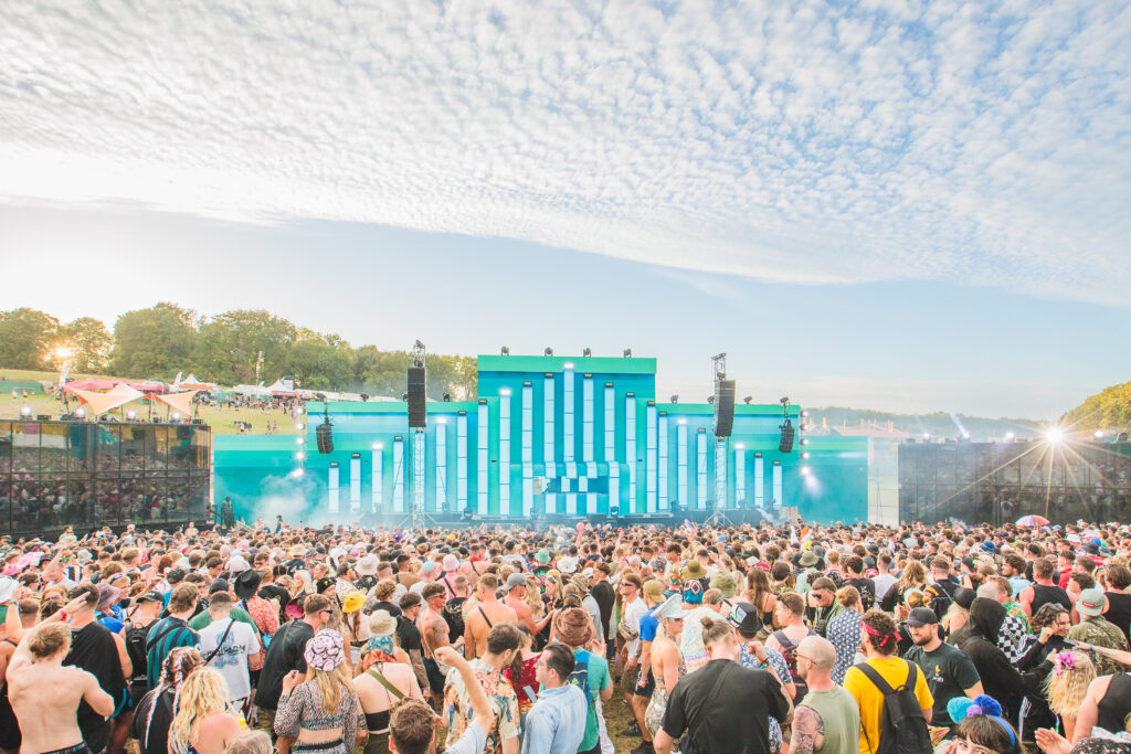 Boomtown crowd under blue sky