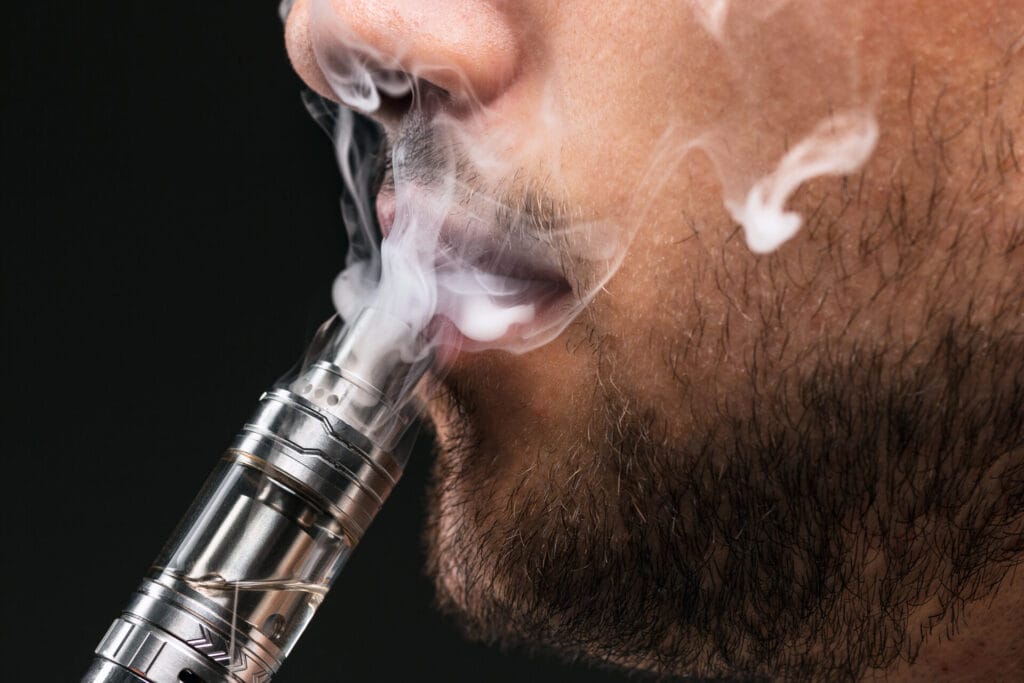 face vaping young man