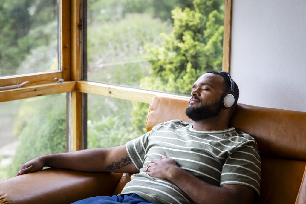 79 percent are stuck in a music rut with one in five admitting they dont make an effort to try and keep up to date with the latest music trends A mid adult man listening to music through wireless headphones and sitting back on a leather sofa in his living room at home in Hexham, North East England. He is listening to the music while looking content with his eyes closed.
