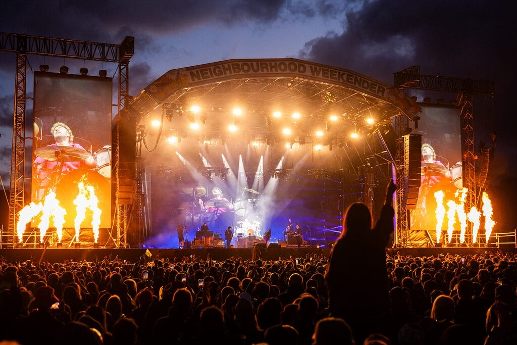 Neighbourhood Weekender stage lit up at night with screens and lights and fire
