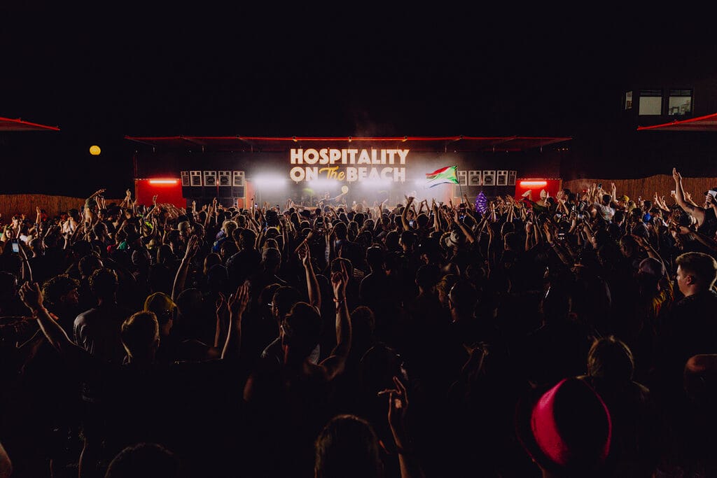 Hospitality on the Beach sign stage crowd