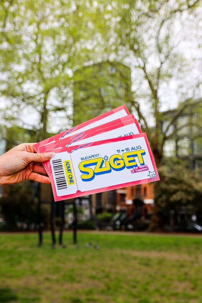 Portrait Sziget competition tickets held up against city scene