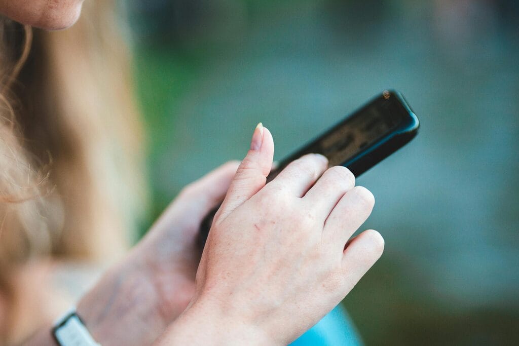 Festival-goer reviewing product information on a phone outdoors